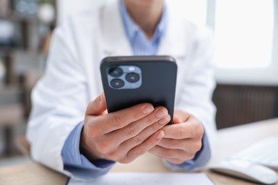 Photo of Doctor with smartphone in clinic, closeup. Online medical consultation