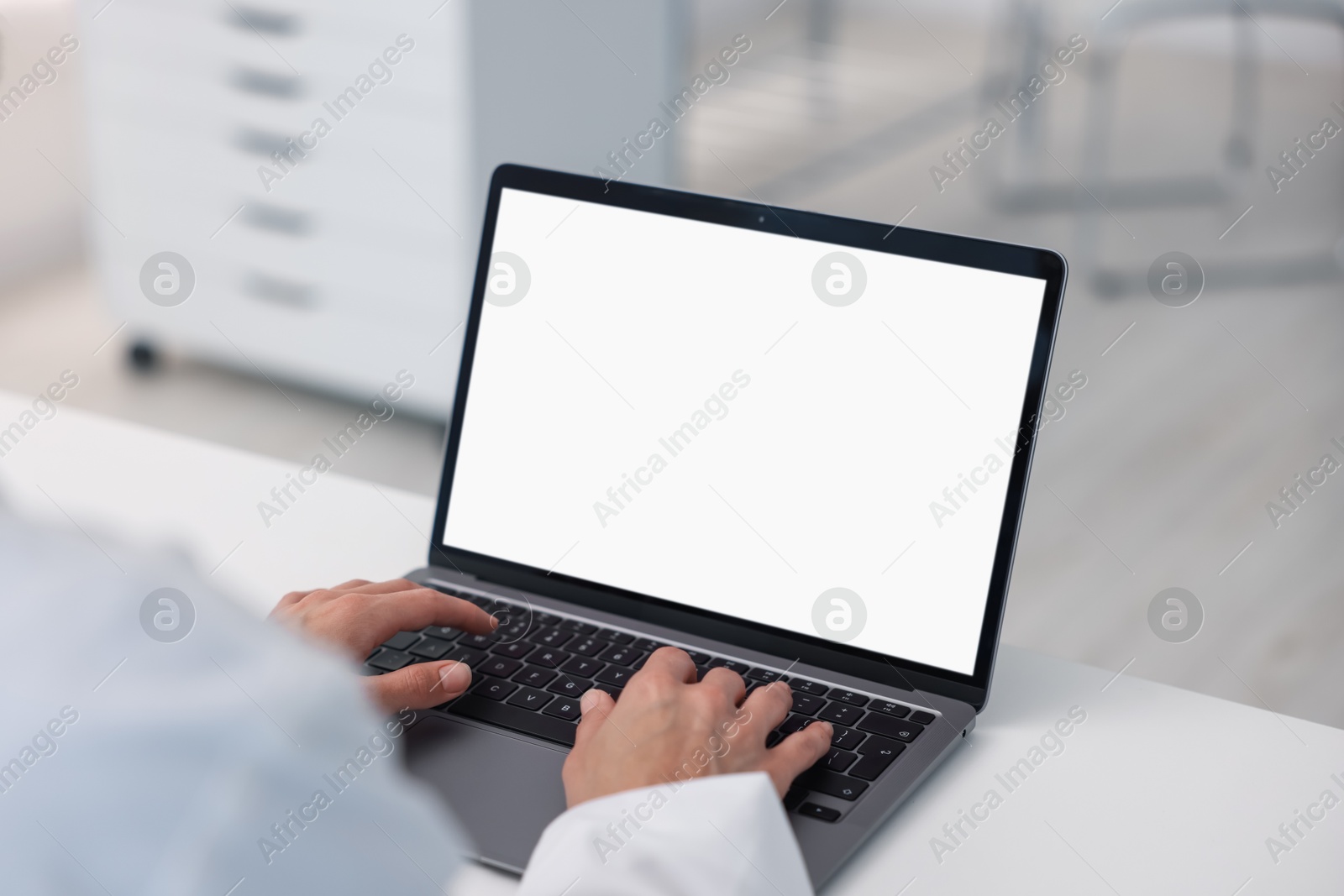 Doctor using laptop in clinic, closeup. Online medical consultation Photo of Doctor using laptop in clinic, closeup. Online medical consultation