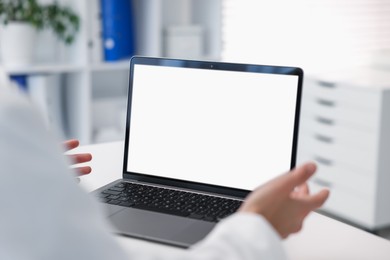 Photo of Doctor having online consultation via laptop in clinic, closeup