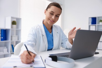 Photo of Doctor having online consultation via laptop in clinic