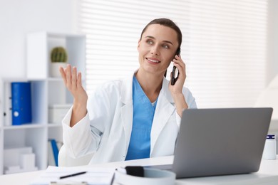 Photo of Doctor with smartphone having online consultation in clinic