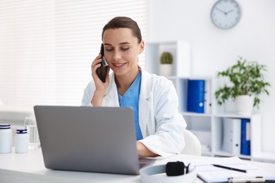 Photo of Doctor with smartphone having online consultation in clinic