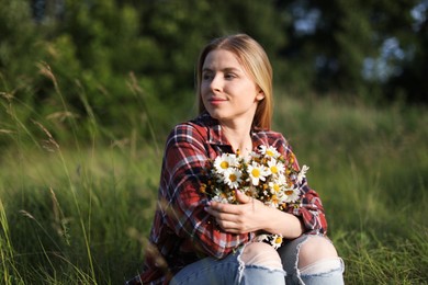 Photo of Beautiful woman with wildflowers enjoying summer day in meadow
