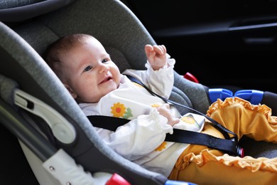 Photo of Cute little baby fastened in car seat