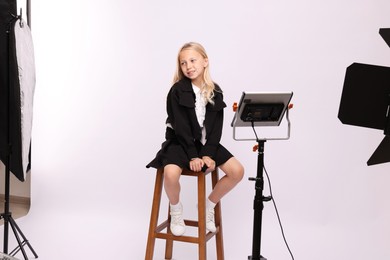 Photo of Little girl on white background in photo studio with professional equipment