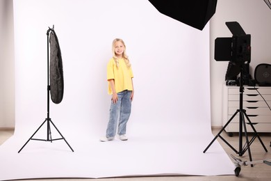 Photo of Little girl on white background in photo studio with professional equipment