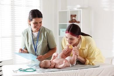 Photo of Mother and her cute baby having appointment with pediatrician in hospital