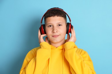 Photo of Teenage boy in headphones on light blue background