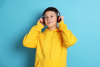 Photo of Teenage boy in headphones on light blue background