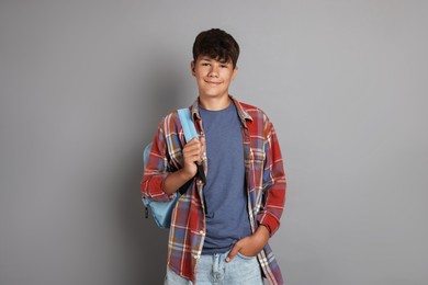Photo of Teenage boy with backpack on grey background