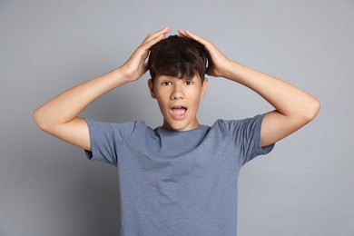 Photo of Portrait of surprised teenage boy on grey background