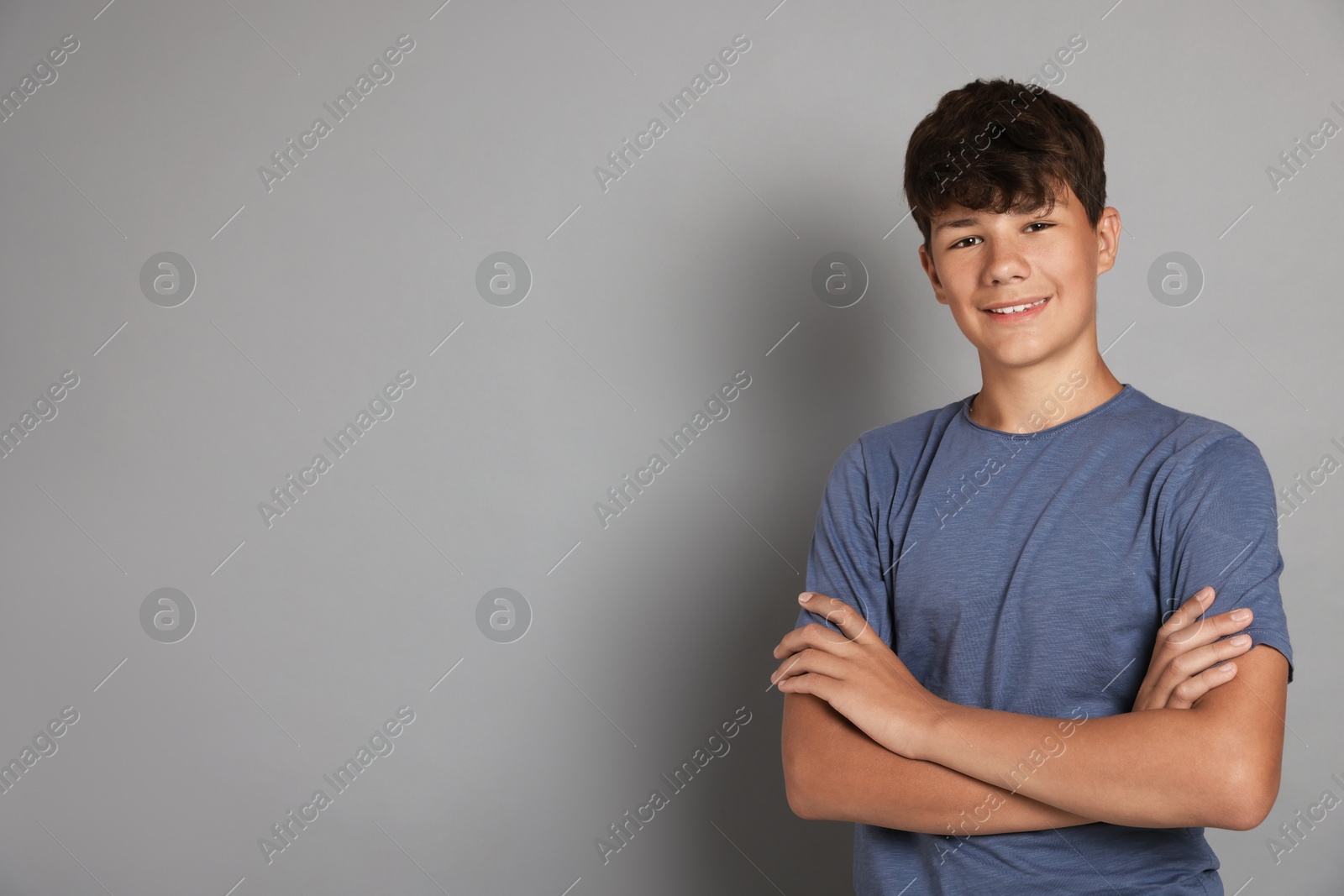 Portrait of teenage boy on grey background, space for text Photo of Portrait of teenage boy on grey background, space for text