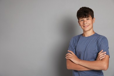 Photo of Portrait of teenage boy on grey background, space for text