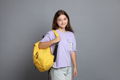 Photo of Teenage girl with backpack on grey background