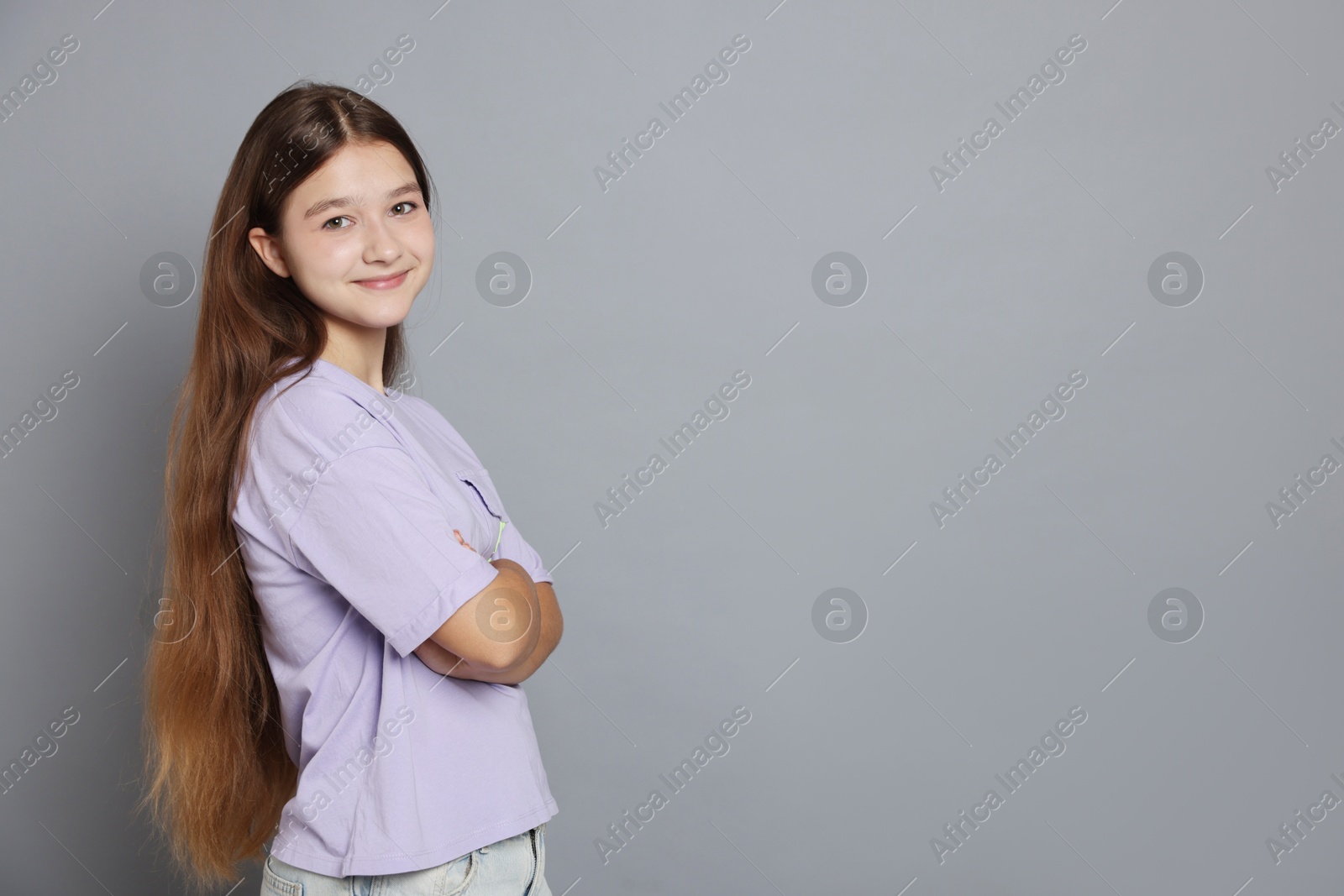 Portrait of teenage girl on grey background, space for text Photo of Portrait of teenage girl on grey background, space for text