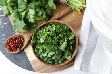 Photo of Fresh green cilantro and peppercorns on white table, top view