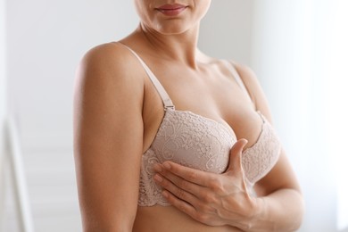 Photo of Woman wearing beautiful bra at home, closeup
