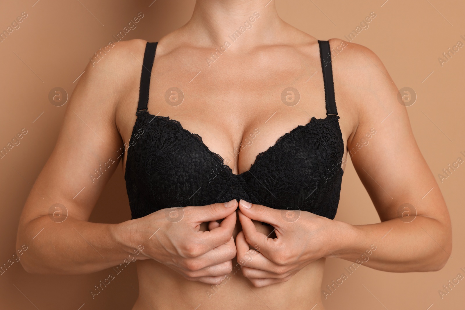 Woman wearing beautiful black bra on beige background, closeup Photo of Woman wearing beautiful black bra on beige background, closeup