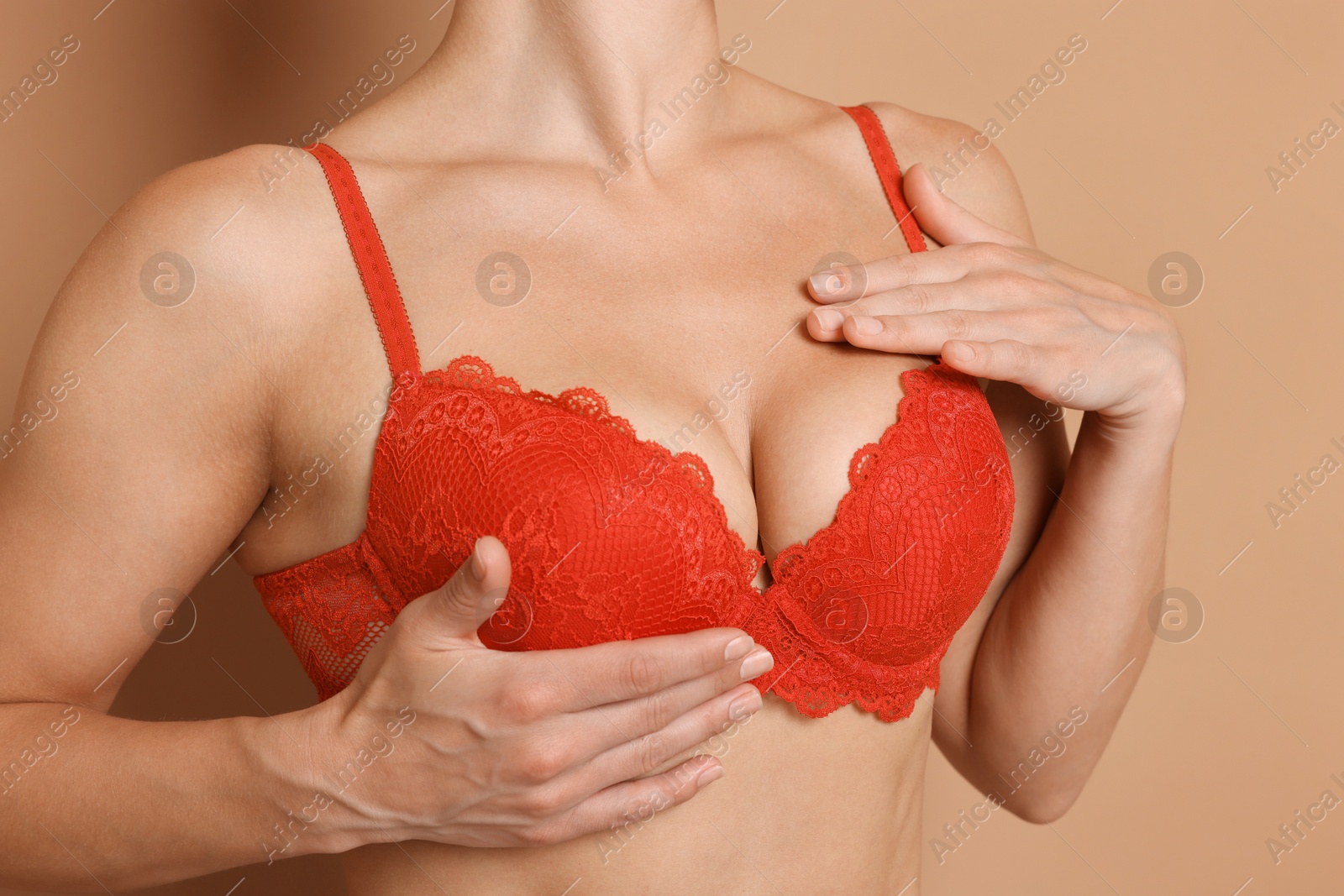 Woman wearing beautiful red bra on beige background, closeup Photo of Woman wearing beautiful red bra on beige background, closeup