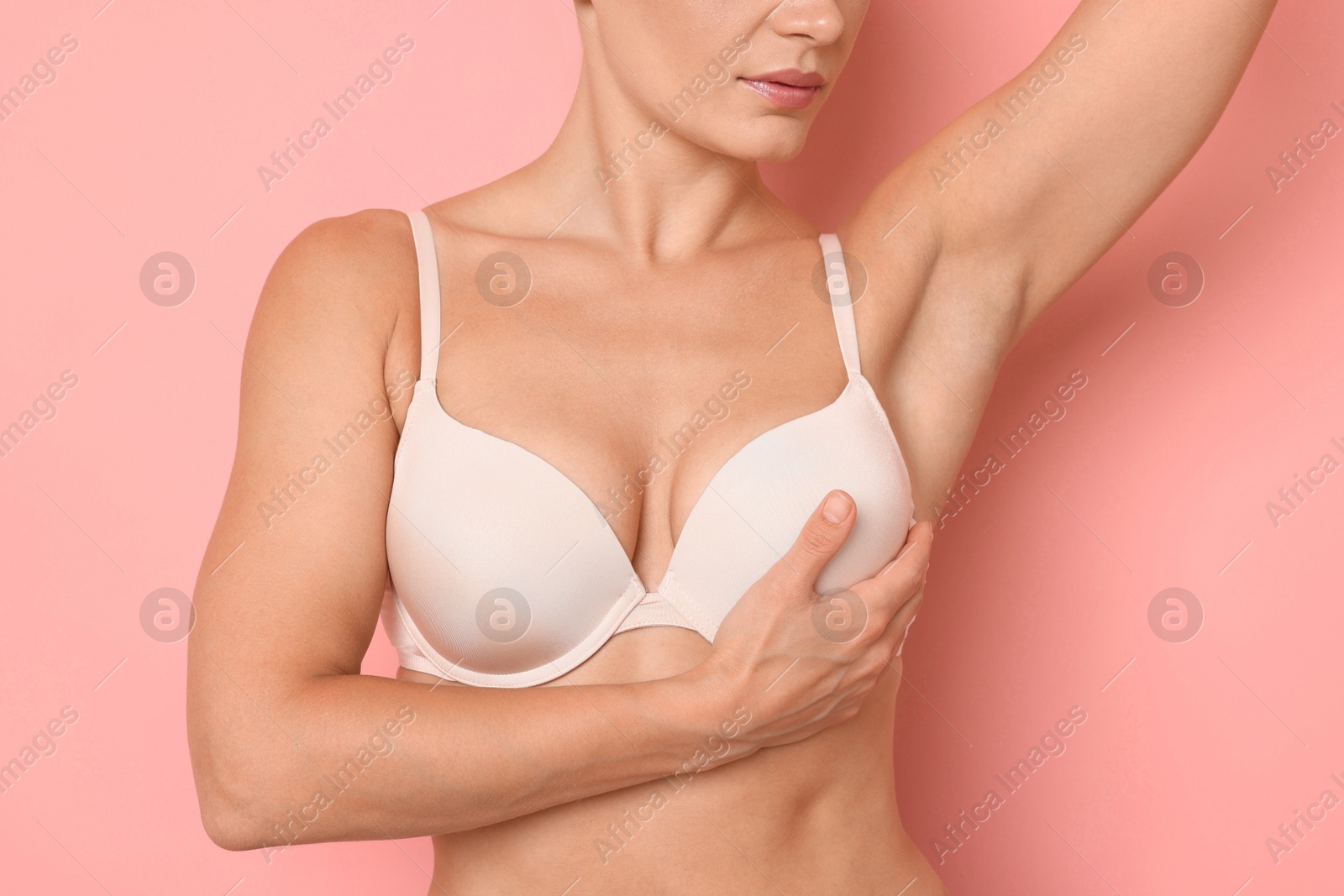 Woman wearing beautiful beige bra on pink background, closeup Photo of Woman wearing beautiful beige bra on pink background, closeup