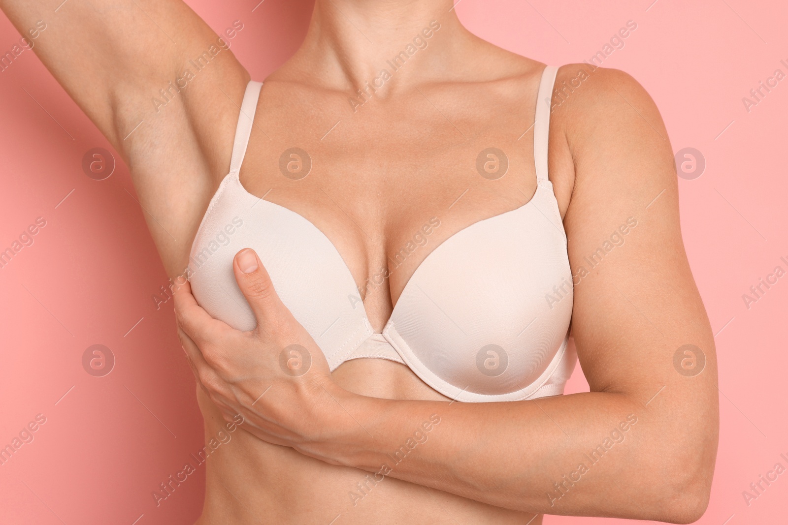 Woman wearing beautiful beige bra on pink background, closeup Photo of Woman wearing beautiful beige bra on pink background, closeup