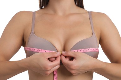Photo of Woman in beautiful bra measuring breast circumference on white background, closeup