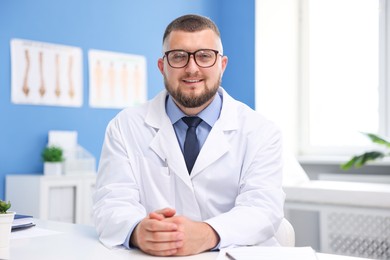 Photo of Doctor in uniform at white table indoors