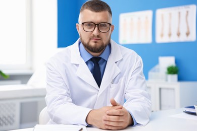 Photo of Doctor in uniform at white table indoors