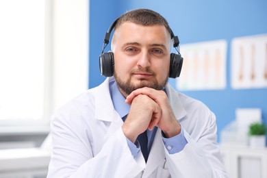 Photo of Doctor in headphones having online consultation indoors