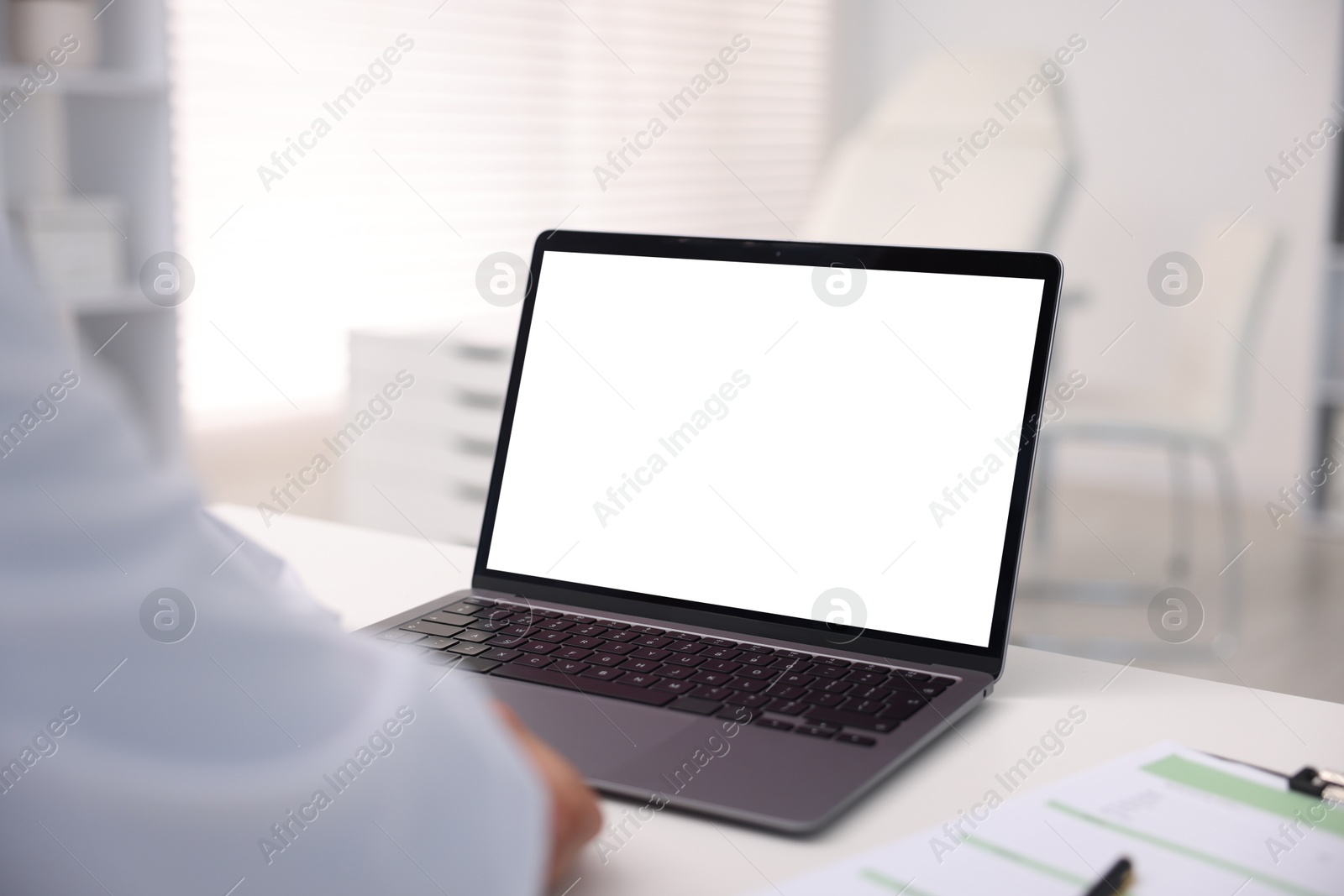 Photo of Doctor having online consultation via laptop in clinic, closeup