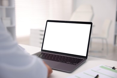 Photo of Doctor having online consultation via laptop in clinic, closeup