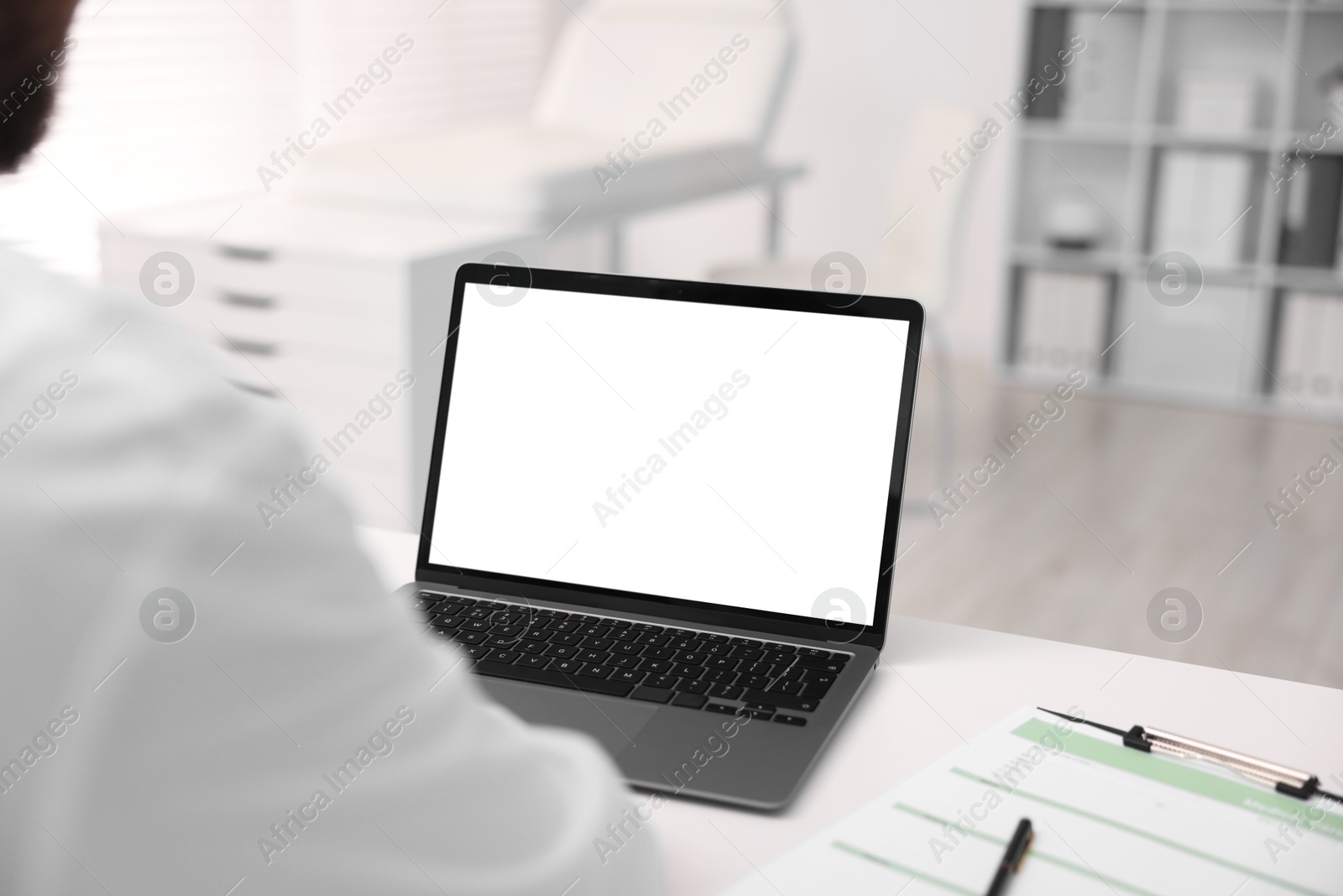 Photo of Doctor having online consultation via laptop in clinic, closeup