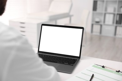 Photo of Doctor having online consultation via laptop in clinic, closeup