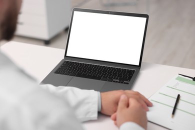 Photo of Doctor having online consultation via laptop in clinic, closeup