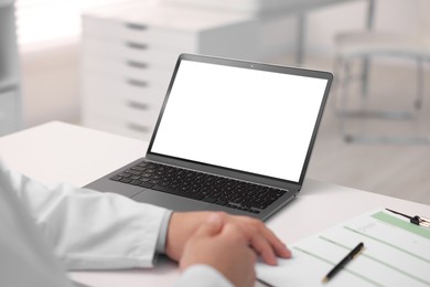 Photo of Doctor having online consultation via laptop in clinic, closeup