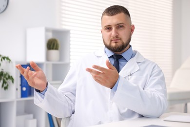 Photo of Portrait of doctor in uniform at table indoors