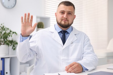 Photo of Portrait of doctor in uniform at table indoors