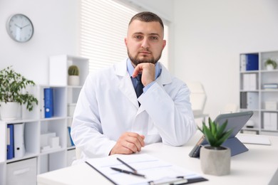 Photo of Portrait of doctor in uniform at table indoors