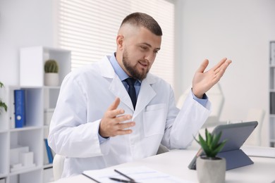 Photo of Doctor having online consultation via tablet indoors
