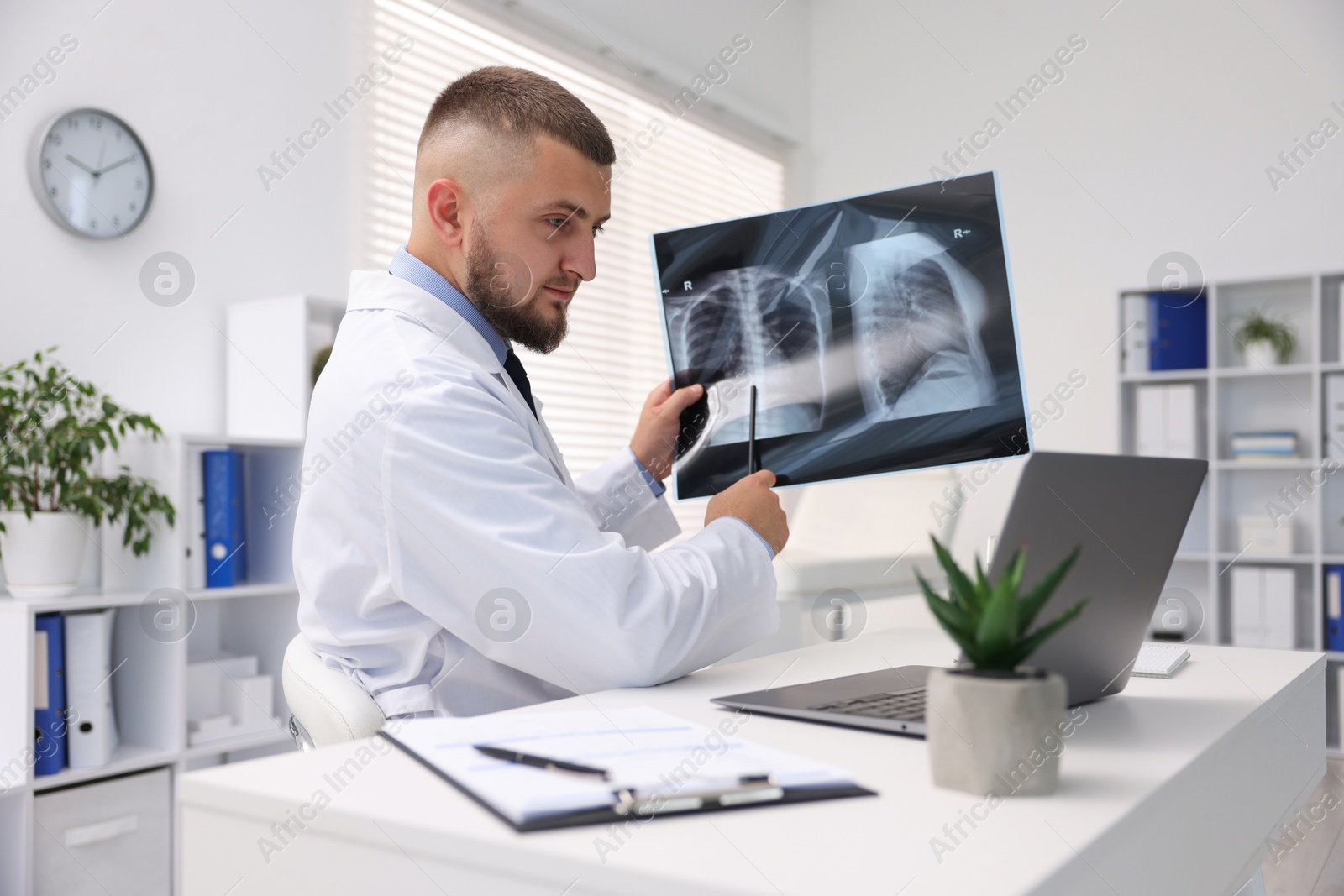 Doctor with lung MRI scan having online consultation via laptop in clinic Photo of Doctor with lung MRI scan having online consultation via laptop in clinic