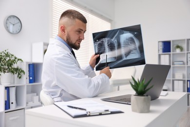Photo of Doctor with lung MRI scan having online consultation via laptop in clinic