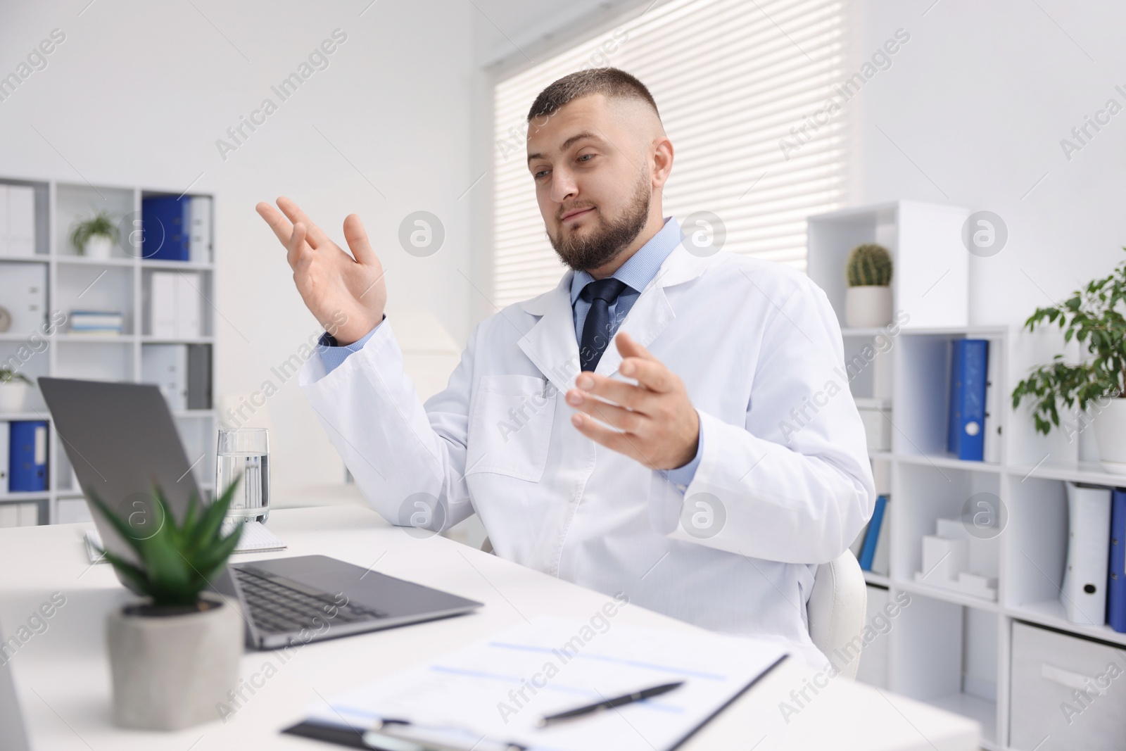 Photo of Doctor having online consultation via laptop in clinic