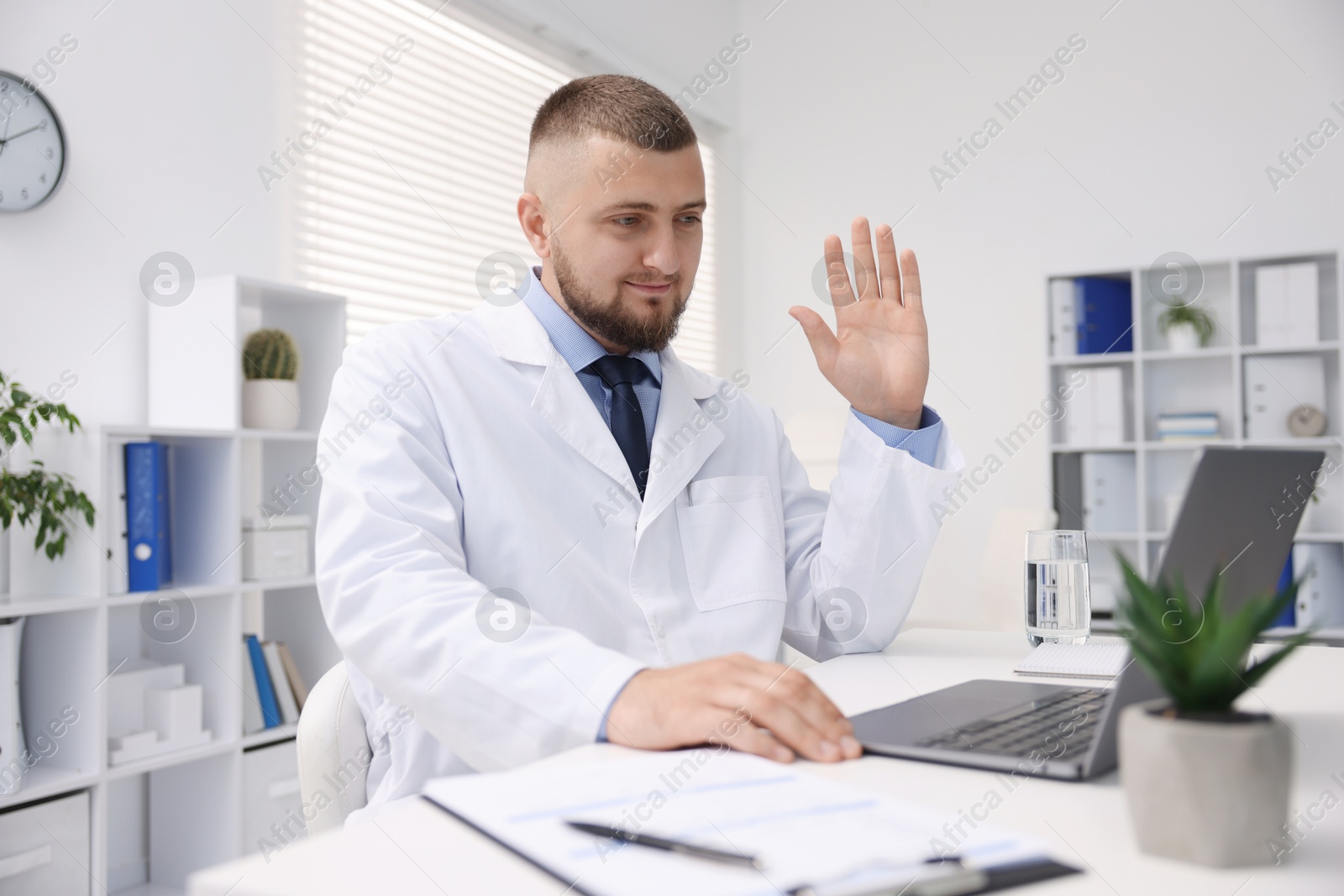 Doctor having online consultation via laptop in clinic Photo of Doctor having online consultation via laptop in clinic