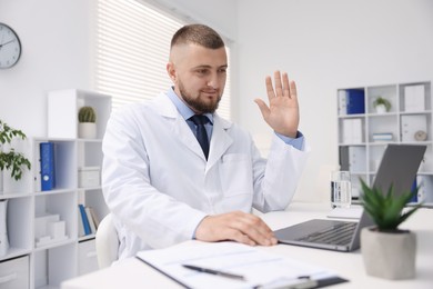 Photo of Doctor having online consultation via laptop in clinic