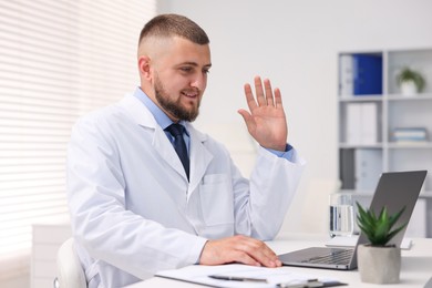 Photo of Doctor having online consultation via laptop in clinic