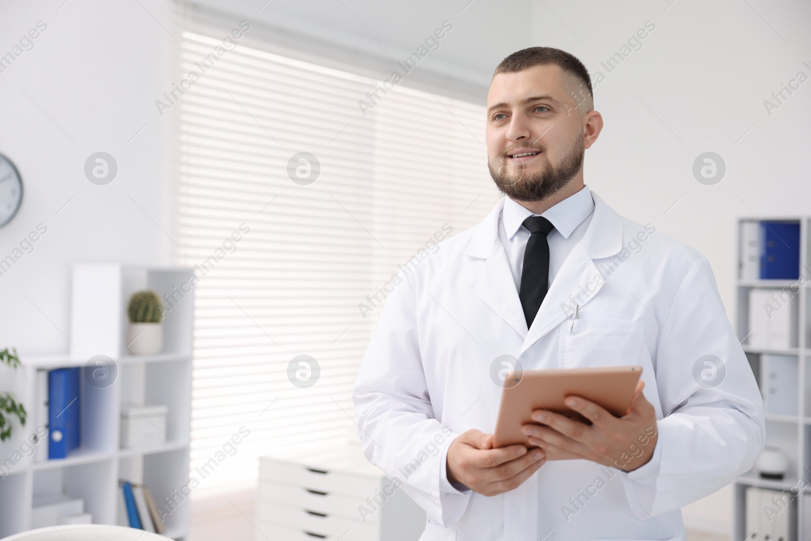 Doctor with tablet in clinic, space for text. Online medical consultation Photo of Doctor with tablet in clinic, space for text. Online medical consultation