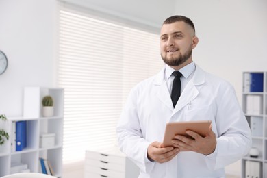 Photo of Doctor with tablet in clinic, space for text. Online medical consultation