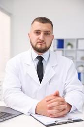 Photo of Portrait of doctor in uniform at table indoors