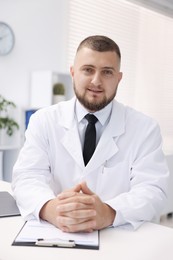 Photo of Portrait of doctor in uniform at table indoors