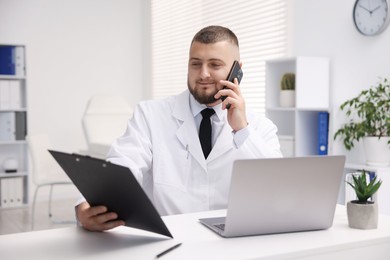 Photo of Doctor with smartphone having online consultation in clinic